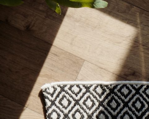 a vase of flowers sitting on top of a wooden floor