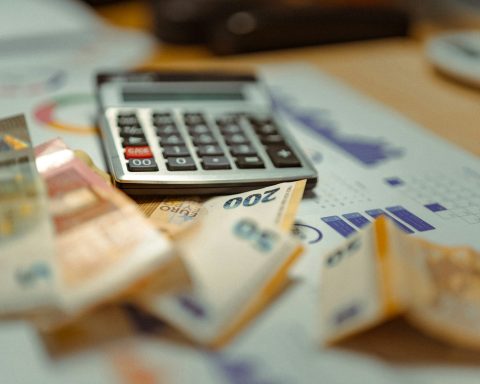 A calculator sitting on top of a pile of money