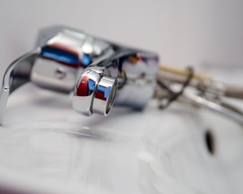 Monteur inspecteert een kapotte wasmachine tijdens een reparatie thuis