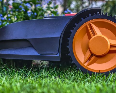 Een robotmaaier rijdt zelfstandig over een groen gazon in een achtertuin